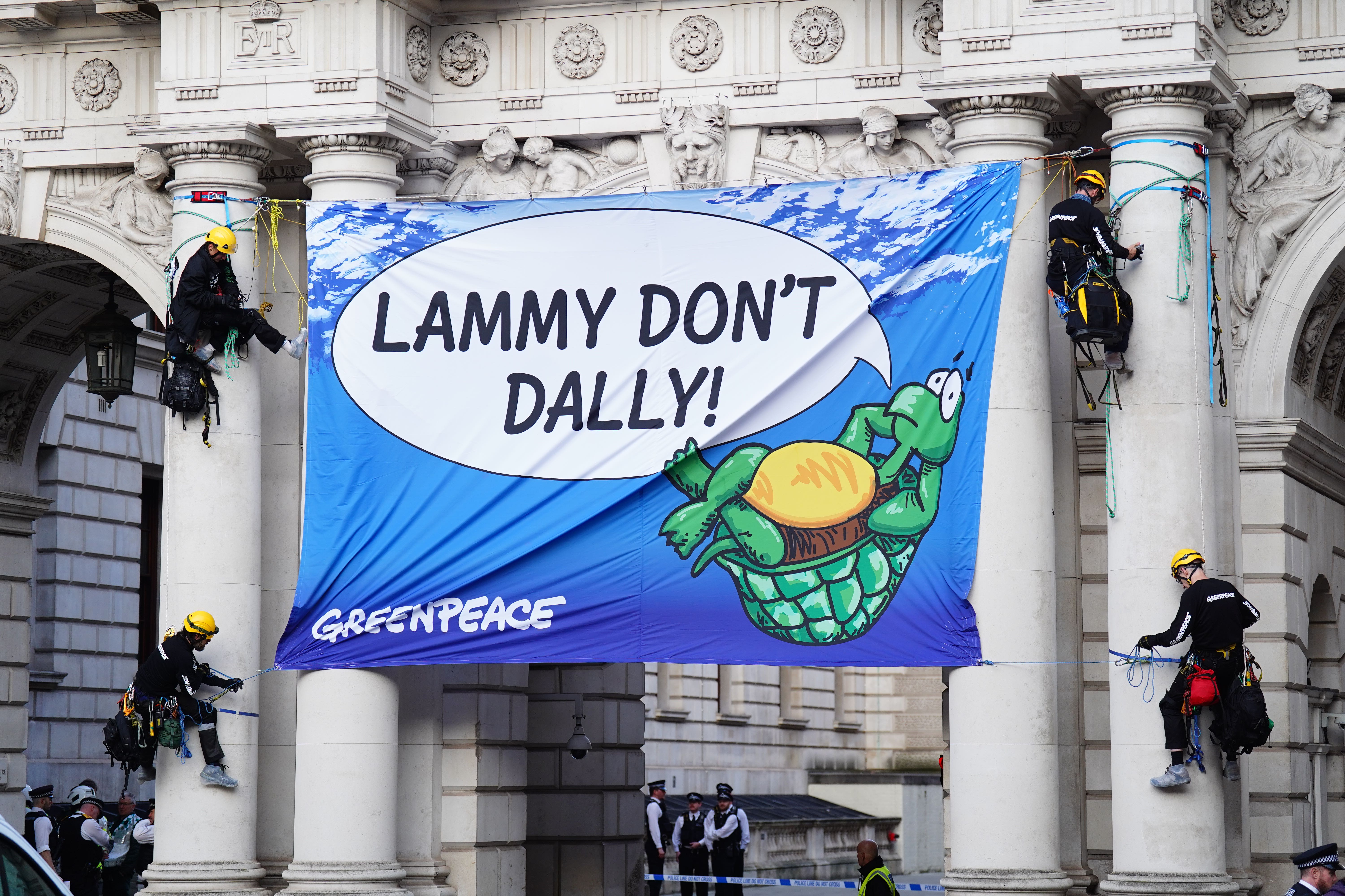 The activists unfurled a banner on the archway (James Manning/PA)